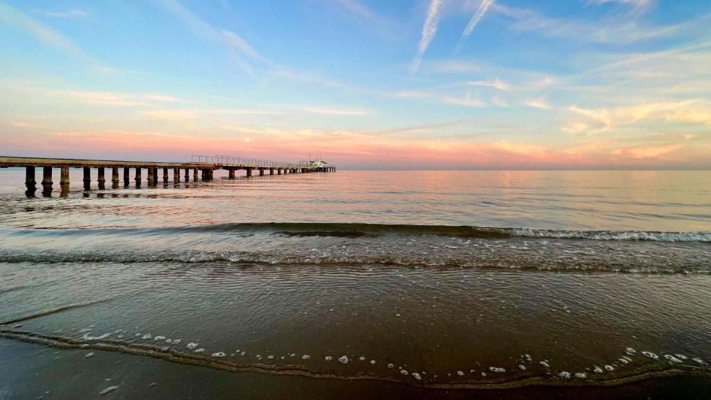 a pier in the ocean with the ocean at Hotel President in Lignano Sabbiadoro