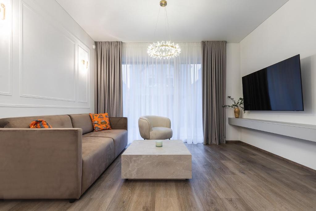 a living room with a couch and a tv at Amber Stone Apartment 1st floor in Palanga