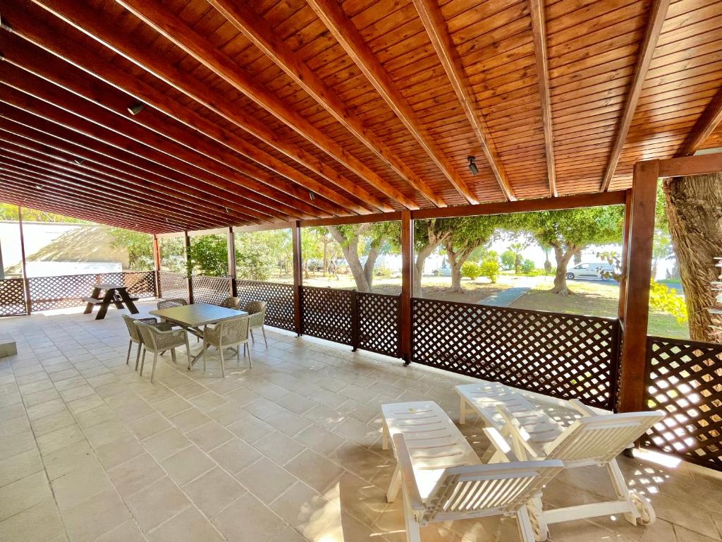 a covered patio with chairs and a table and a table and chairs at Dream Beachfront Bungalow in Limassol