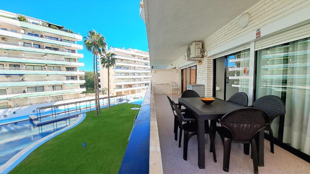 薩洛的住宿－Apartamentos Riviera Niza 05，一个带桌椅的阳台和一个游泳池