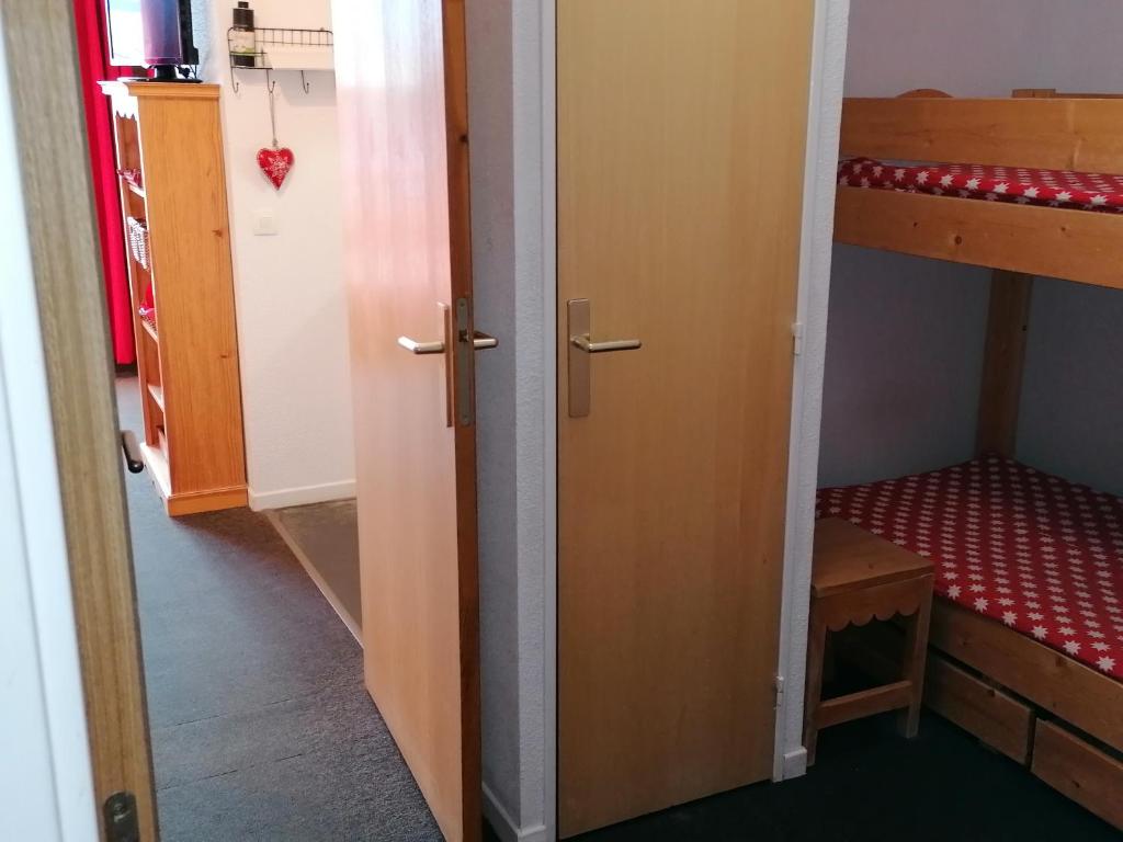 a room with two bunk beds and a door at RISOUL 1850 Appartement T2 confortable skis aux pieds à 300 m centre in Risoul
