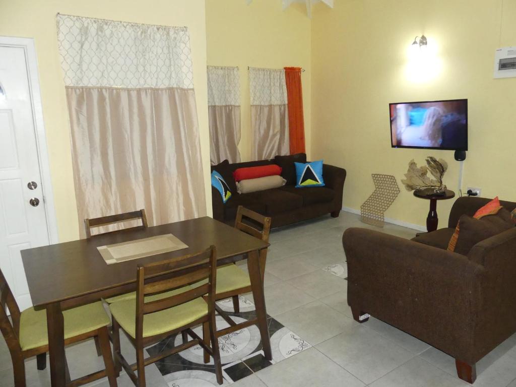 a living room with a table and a couch at Southern Haven Guesthouse in Laborie