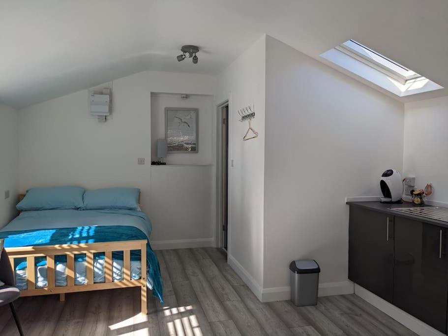 1 dormitorio pequeño con 1 cama y cocina en Seaside guest house a stone's throw from the beach, en Dawlish