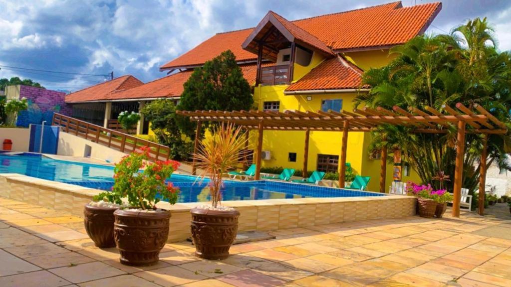une villa avec une piscine et une maison dans l'établissement Pousada Granville, à Campina Grande