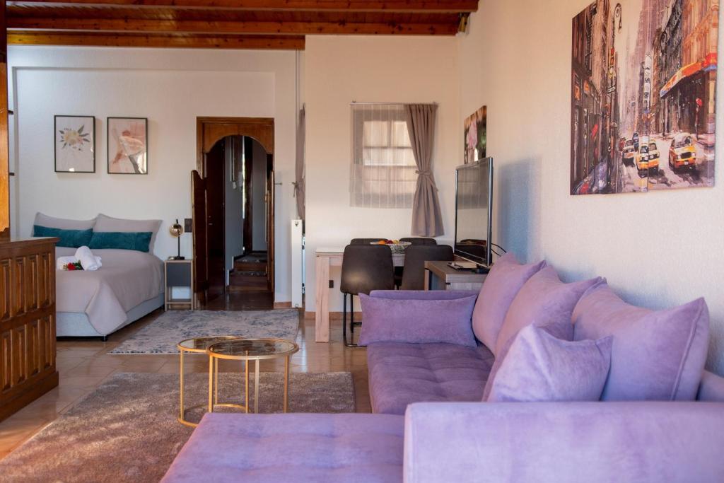 sala de estar con sofá púrpura y cama en Stathohouse, en Filiatra