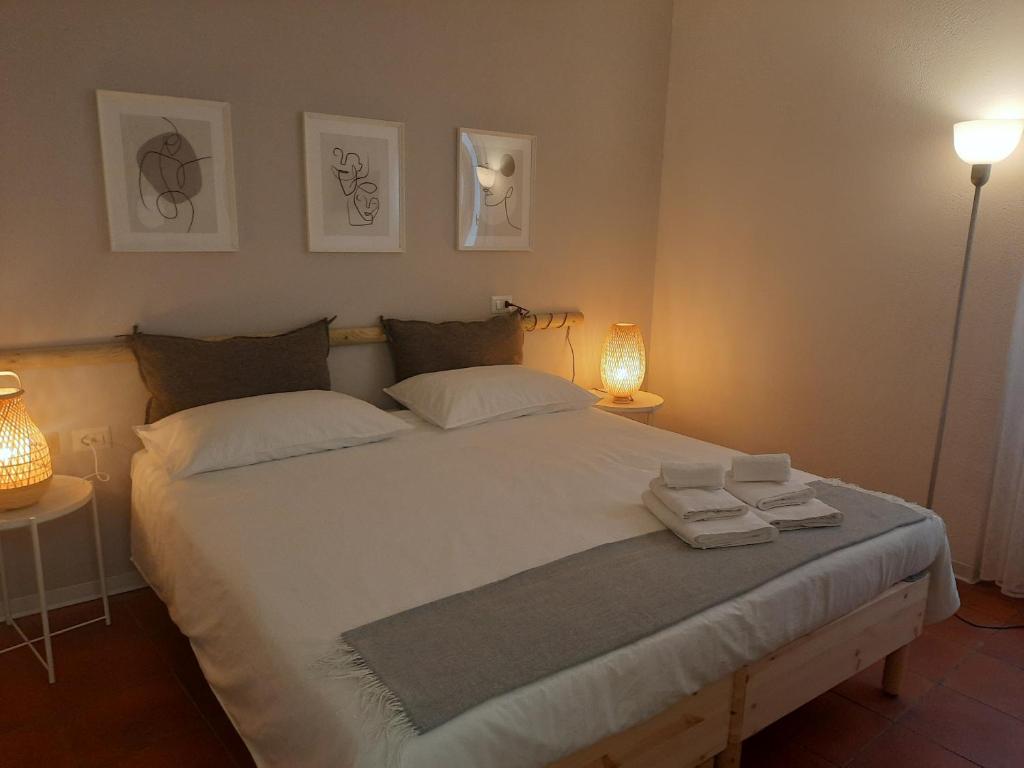 1 dormitorio con 1 cama blanca grande y toallas. en Contrada d'Amore, en Angera