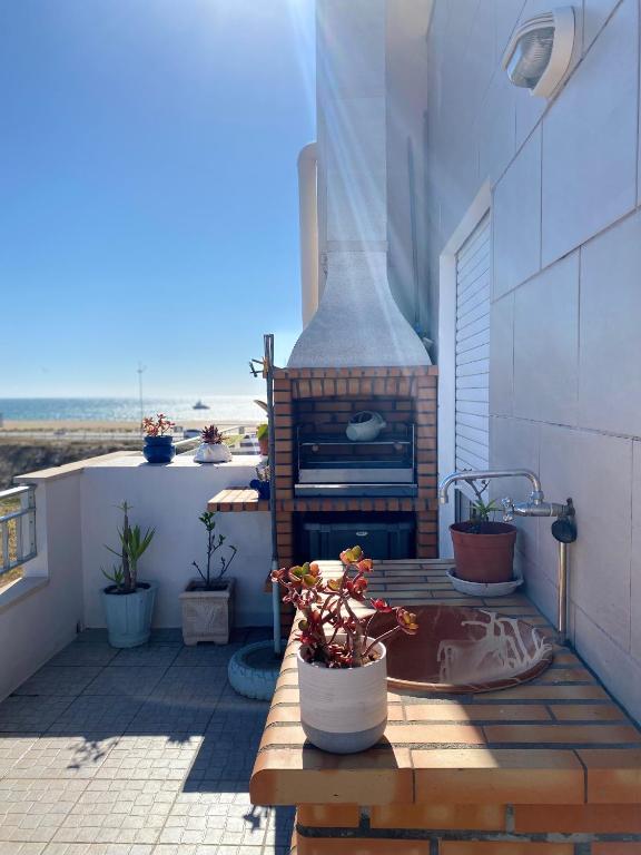 a outdoor patio with a fireplace and potted plants at Rito´s Paradise in Nazaré
