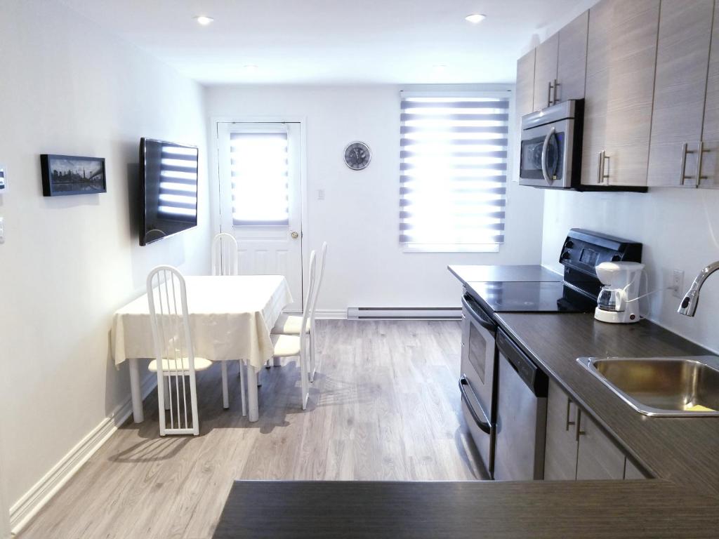 uma cozinha com uma mesa e uma sala de jantar em A&I Cosy&Bright Apartments near Old Port and South Shore em Longueuil