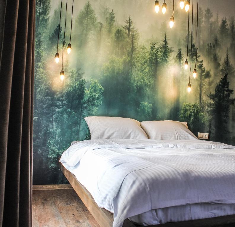 - une chambre avec un lit en face d'une fresque murale représentant la forêt dans l'établissement Casavilla Kartalkaya, à Kındıra