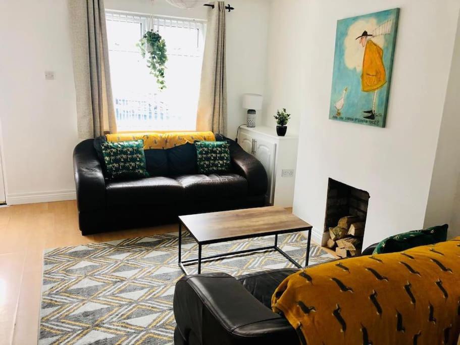 uma sala de estar com um sofá e uma mesa em Cosy House, Lisburn Road em Belfast