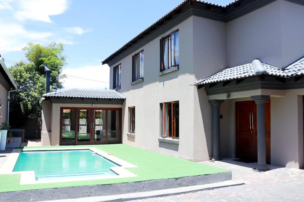 a house with a swimming pool in front of it at Modern Home in Pretoria in Pretoria
