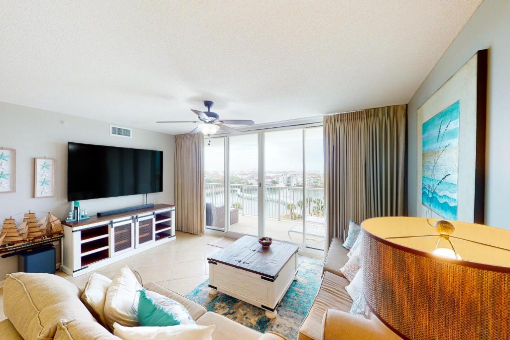 a living room with a couch and a tv at The Terrace at Pelican Beach 504 in Destin