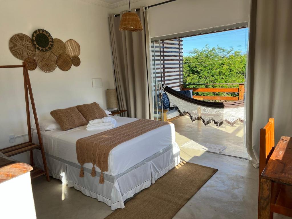 um quarto com uma cama e vista para uma varanda em Flats Corumbau em Corumbau