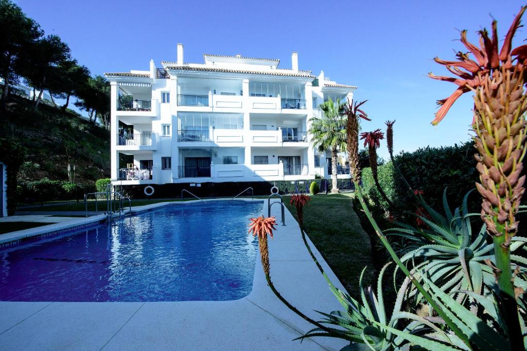 un gran edificio blanco con una piscina frente a él en Apartment Summer Vibes Miraflores - La Cala de Mijas, en La Cala de Mijas