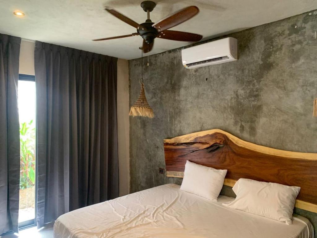 1 dormitorio con 1 cama y ventilador de techo en Condominio Pacha en Tulum, en Tulum