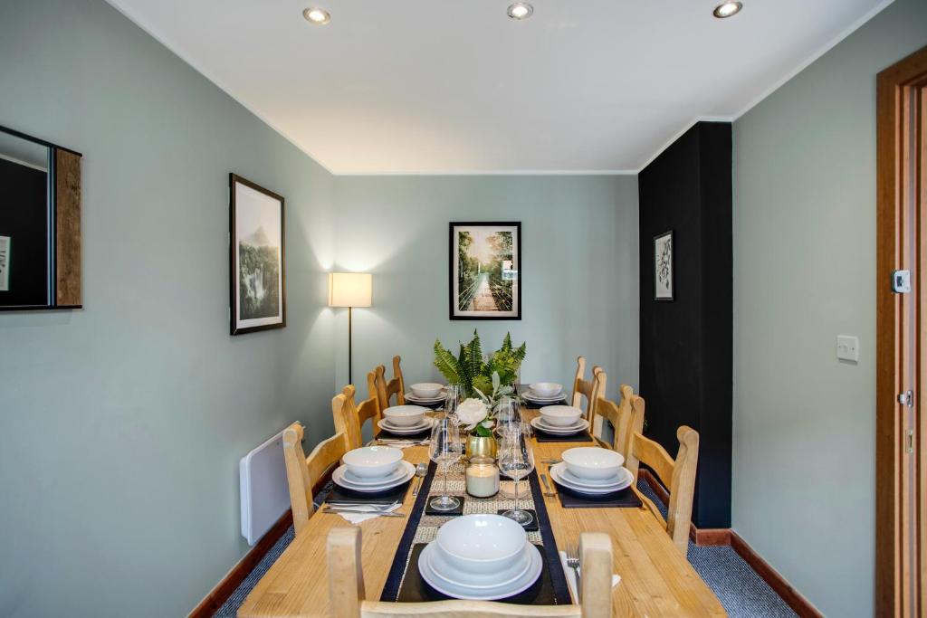 Un comedor con mesa y sillas de madera. en New! Peaceful 4 Bed home - Quiet and Cosy, en Kent