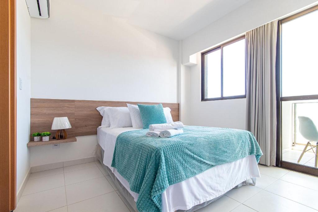 a bedroom with a bed and a large window at Mana Beach #B217 - Quadrúplo por Carpediem in Porto De Galinhas