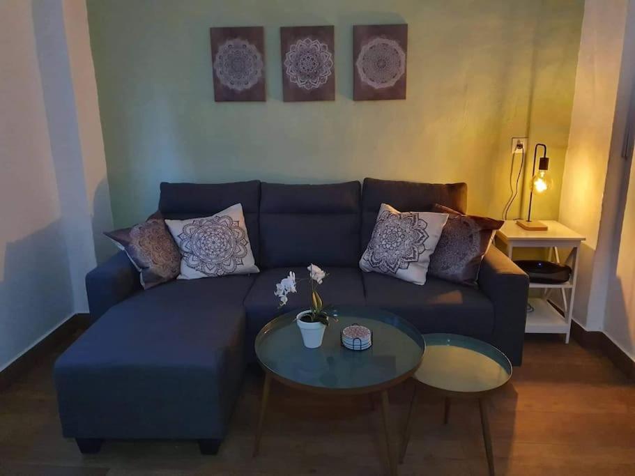 a living room with a blue couch and two tables at Olive Tree self-catering accommodation in Olvera