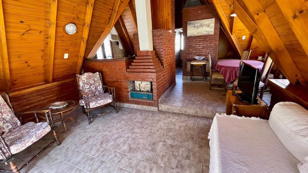 vistas a una habitación con sillas y chimenea en La Cabaña de Puerto Madryn en Puerto Madryn