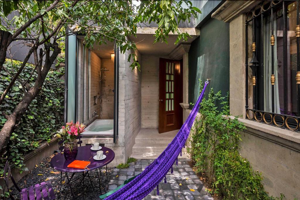 a purple hammock outside of a house with a table at Pug Seal Polanco Anatole France in Mexico City