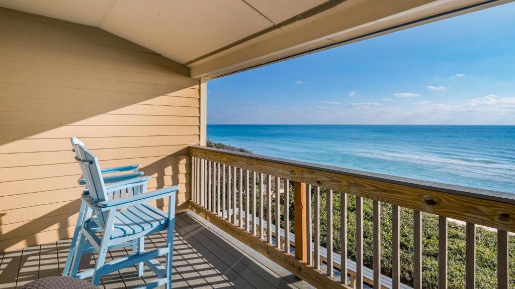 a blue rocking chair on a balcony with the ocean at Blue Nine 2 in Panama City Beach