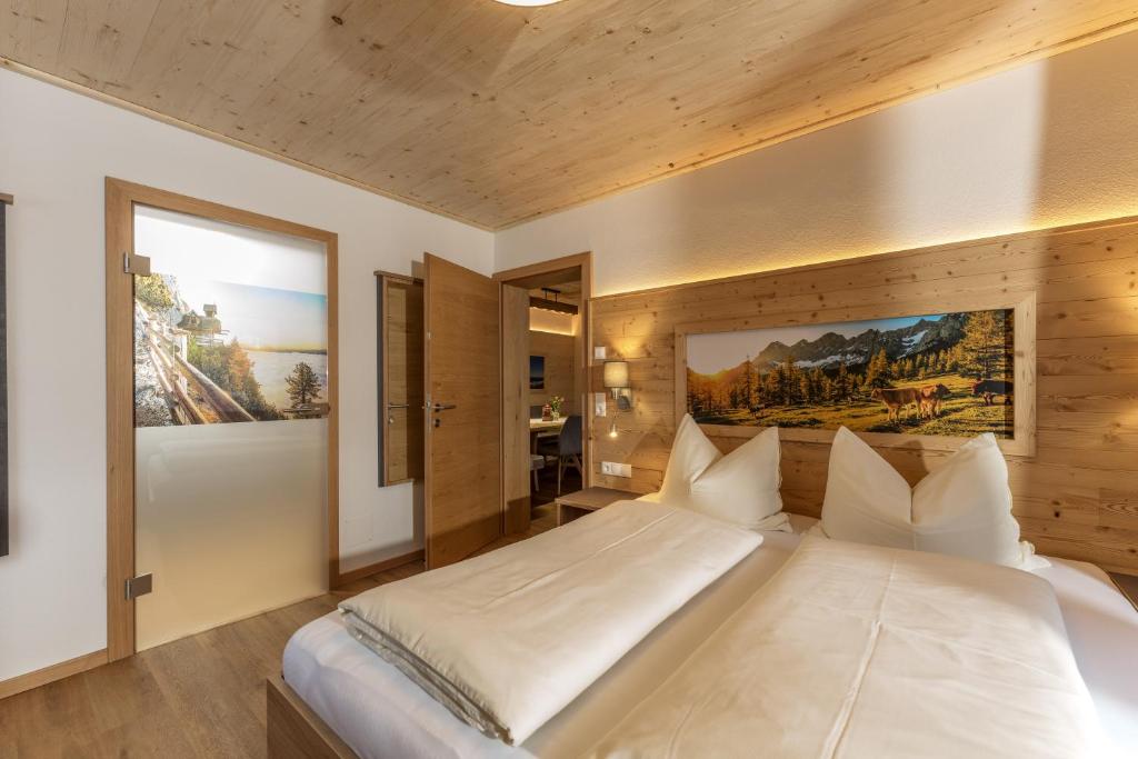 um quarto com uma grande cama branca num quarto em Pircherhof Appartements em Haus im Ennstal