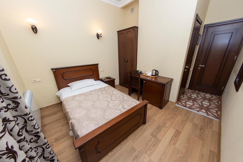 a bedroom with a bed and a wooden floor at Eiffel Hotel in Batumi