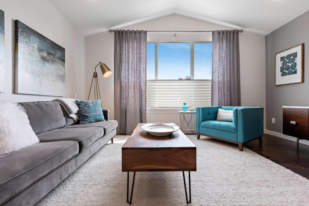uma sala de estar com um sofá cinzento e uma cadeira azul em Brit and Belle Townhouse em Boise
