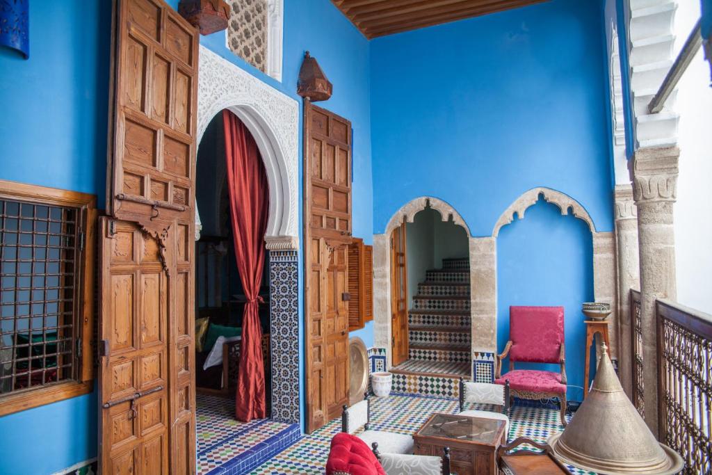 ラバトにあるDar Shaeirの青い壁と木製のドアが特徴の客室です。