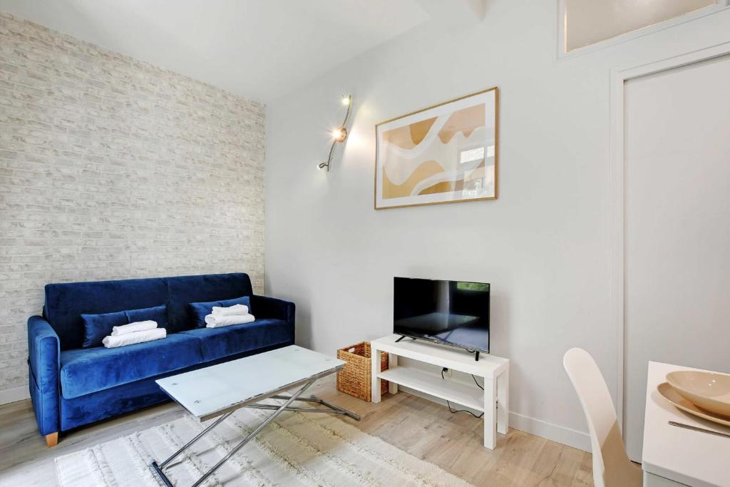 un salon avec un canapé bleu et une télévision dans l'établissement Charming apartment - 1BR-4P - Montparnasse, à Paris