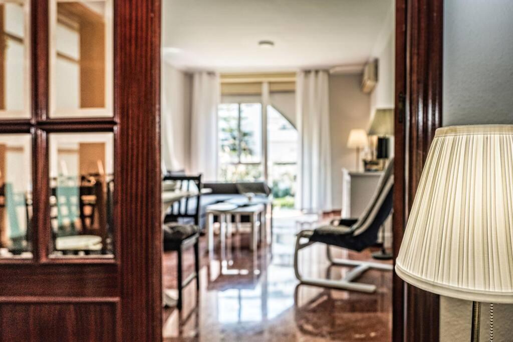 塞維利亞的住宿－Apartamento New Folch Sevilla A，客厅配有椅子、桌子和台灯
