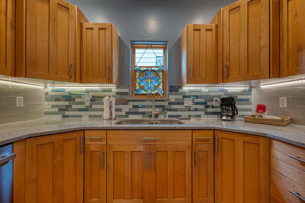 una cucina con armadi in legno, lavandino e finestra di Home Amongst the Trees a Boise
