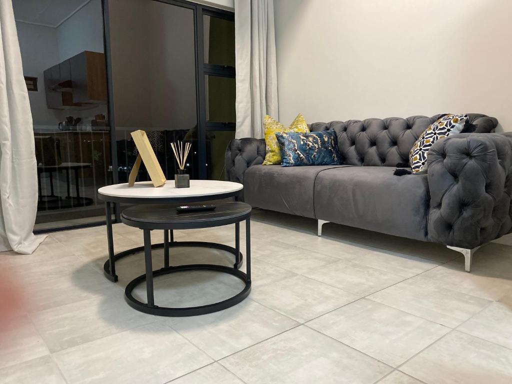 a living room with a couch and a table at Outer Space - 1 bedroom Luxurious Apartment in Sandton in Sandown