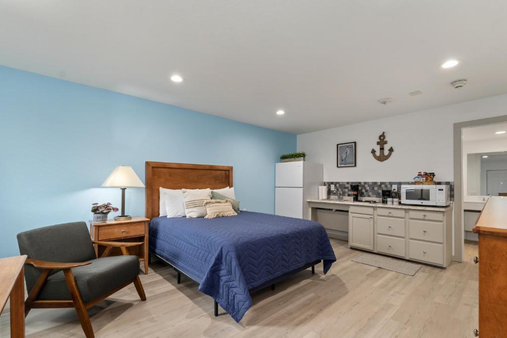 a bedroom with blue walls and a bed and a kitchen at Extended Stay Gun Barrel City in Gun Barrel City