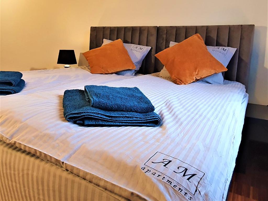 uma cama com toalhas e almofadas em cima em Szczecin Centrum 1 em Szczecin