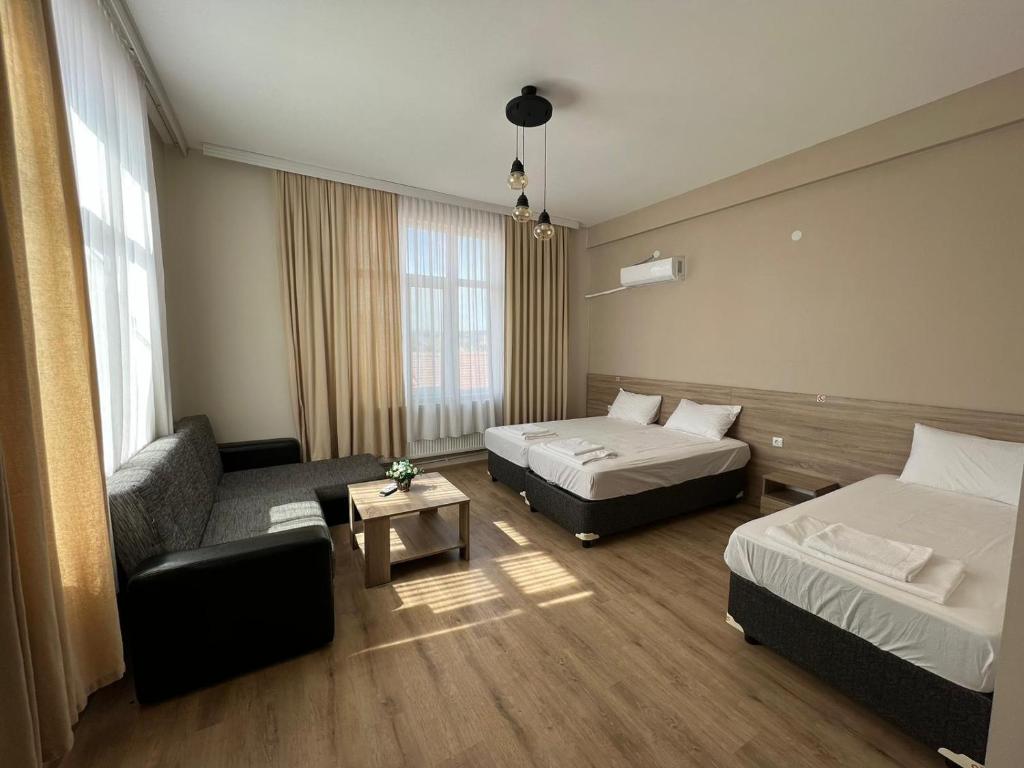 Habitación de hotel con 2 camas y sofá en Hotel Tatul, en Momchilgrad
