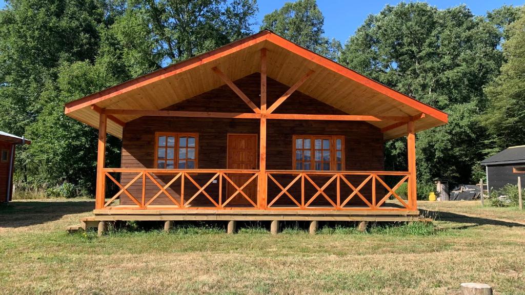 a small log cabin in the middle of a field at Cabañas Rukafun 2 in Pucón