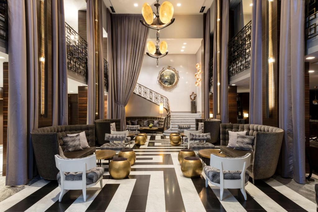 a lobby of a hotel with chairs and tables at Empire Hotel in New York