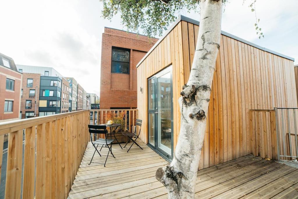 a wooden deck with a tree on the side of a building at Carmen Eco-Pod / Treehouse, Close to Cabot Circus in Bristol