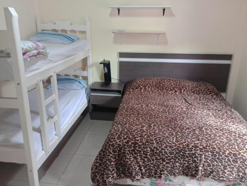 - une chambre avec deux lits superposés et un lit avec un couvre-lit dans l'établissement ALOJAMIENTO TEMPORARIO, à Paso de los Libres