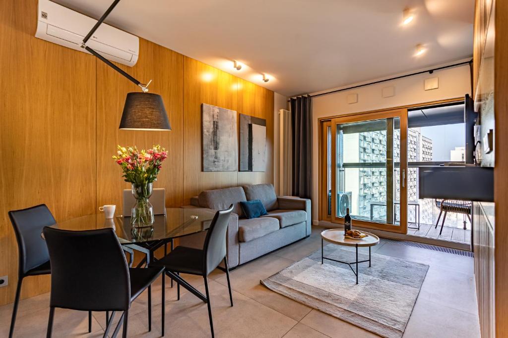 een woonkamer met een tafel en een bank bij Mennica Residence Apartments by P&O Serviced Apartments in Warschau