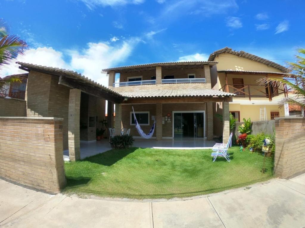 a house with a lawn in front of it at Solar Leão Beach in Luis Correia