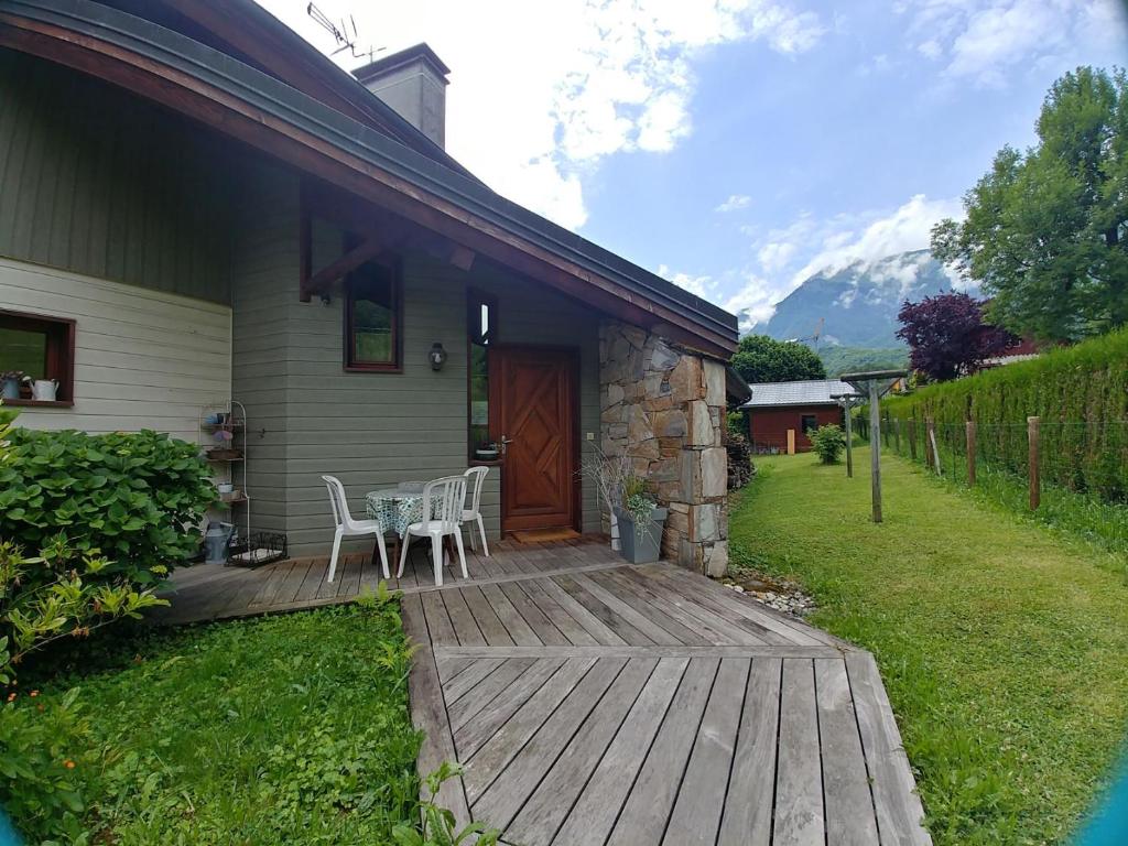 uma casa com um deque de madeira com uma mesa e cadeiras em Rêverie Champêtre em Verrens-Arvey