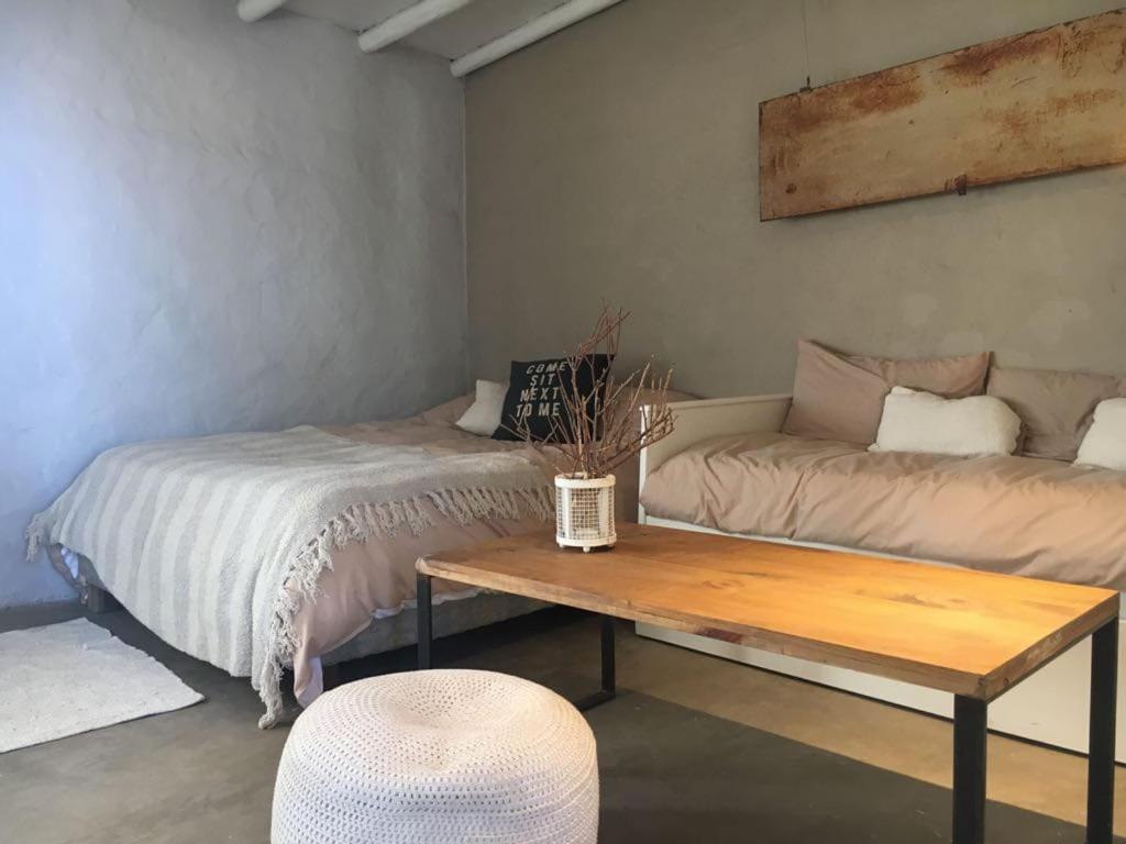 Habitación con cama, mesa y sofá en Tierra de Leones en Rodeo