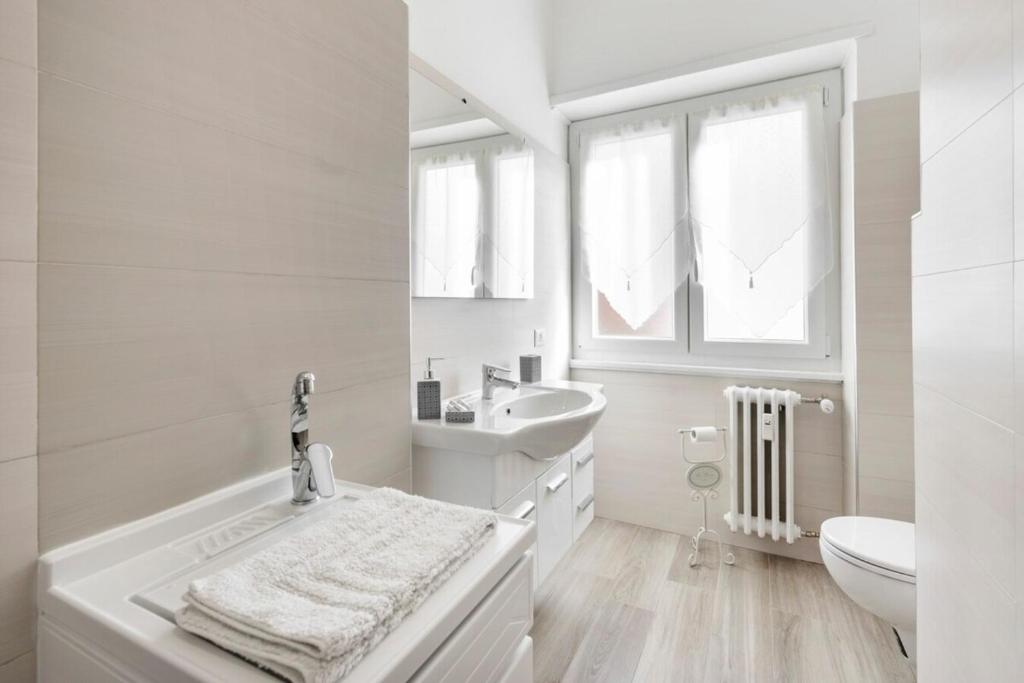 biała łazienka z umywalką i toaletą w obiekcie Regina Luxury Flat w Rzymie