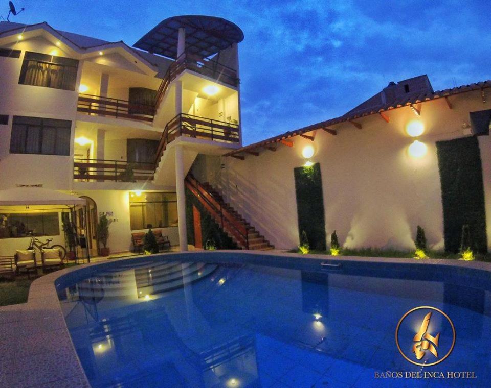 uma casa com piscina em frente a uma casa em Hotel Baños del Inca em Los Baños del Inca