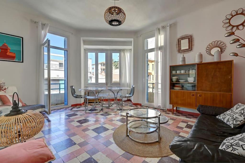 ein Wohnzimmer mit einem Sofa, einem Tisch und Stühlen in der Unterkunft Spacieux et lumineux, idéal T4 en centre ville in Perpignan