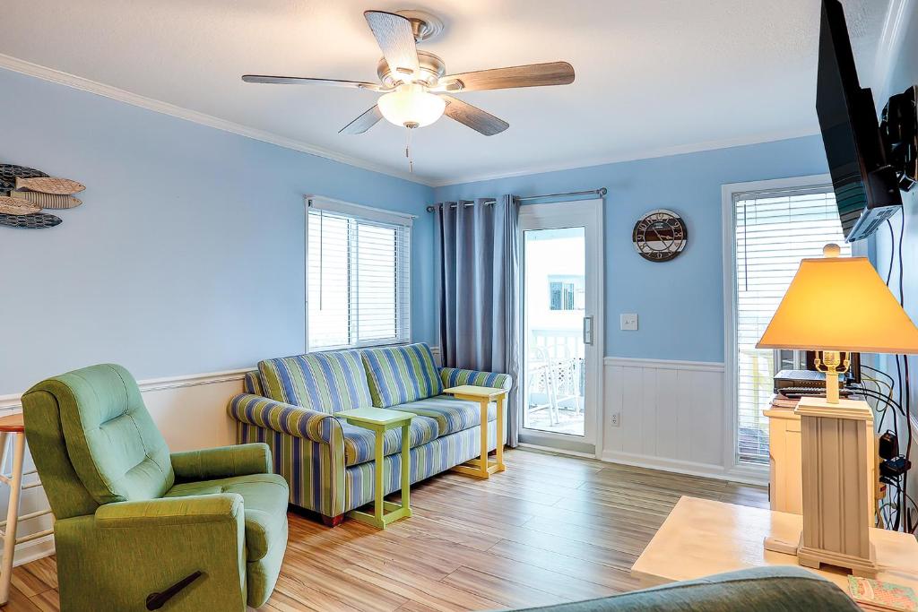 a living room with two chairs and a ceiling fan at Seaspray 134 in Atlantic Beach