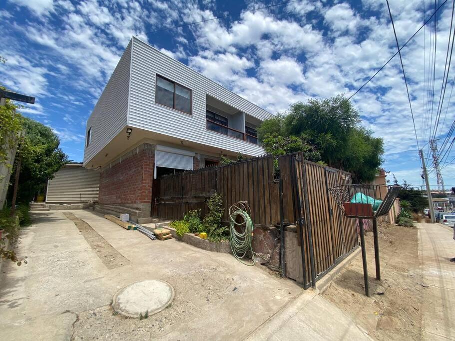 a house with a fence in front of it at Departamento N con hermosa vista al mar in Los Vilos