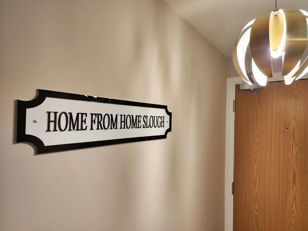 ein Schild mit der Hausversorgung an einer Wand neben einer Tür in der Unterkunft Home from Home Slough in Slough